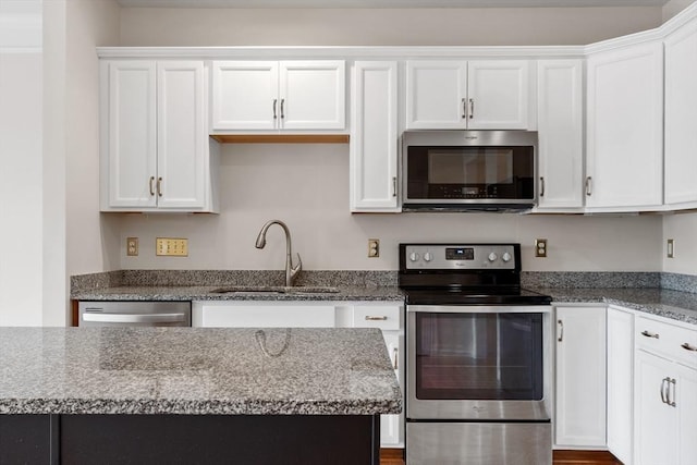 kitchen featuring light stone countertops, sink, white cabinetry, and stainless steel appliances