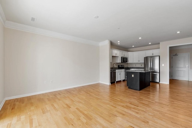 kitchen with a center island, white cabinets, sink, light hardwood / wood-style floors, and stainless steel appliances