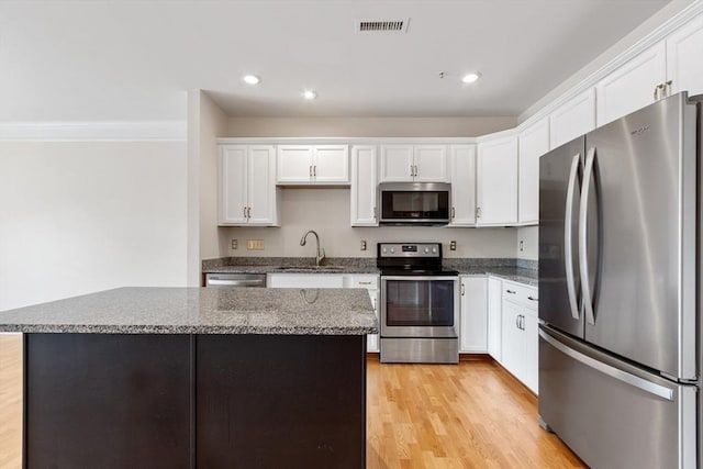 kitchen featuring white cabinetry, sink, a center island, and appliances with stainless steel finishes