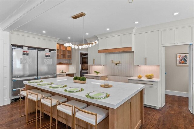 1780 Central Ave, Needham, MA 02492 - kitchen with a kitchen island, dark wood-type flooring, freestanding refrigerator, white cabinets, and recessed lighting