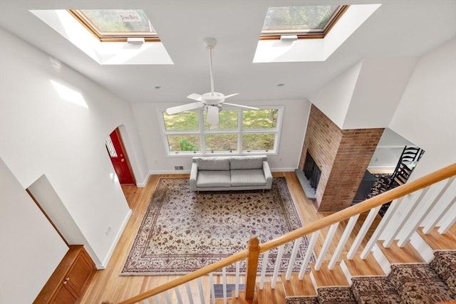 35 Bemis St, Weston, MA 02493 - living area with a skylight, light wood-style floors, a brick fireplace, ceiling fan, and vaulted ceiling