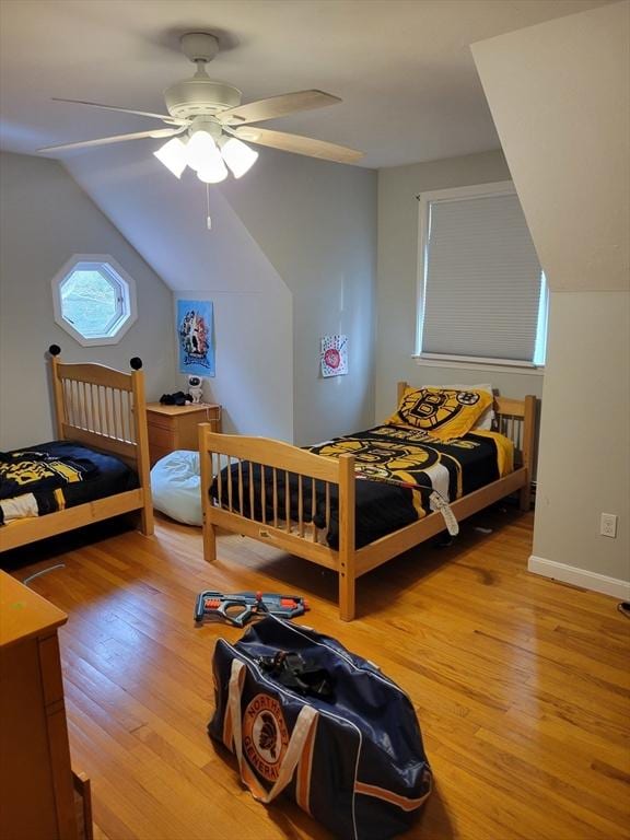 bedroom with lofted ceiling, baseboards, a ceiling fan, and light wood-style floors