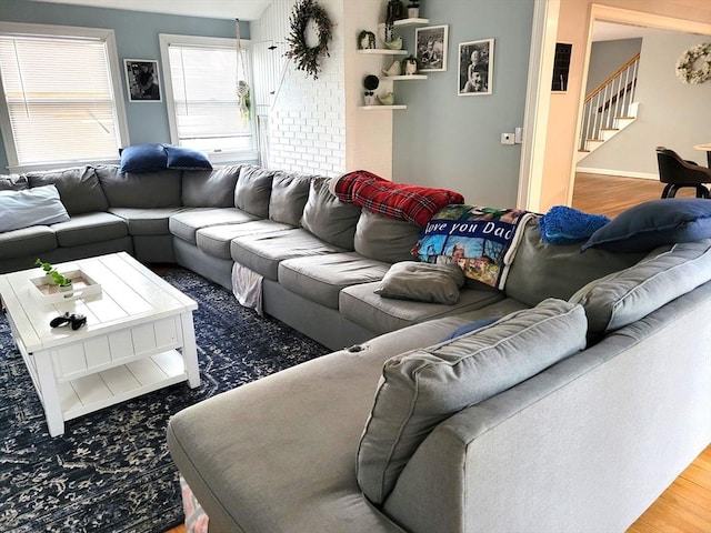 living room with baseboards, stairway, and wood finished floors