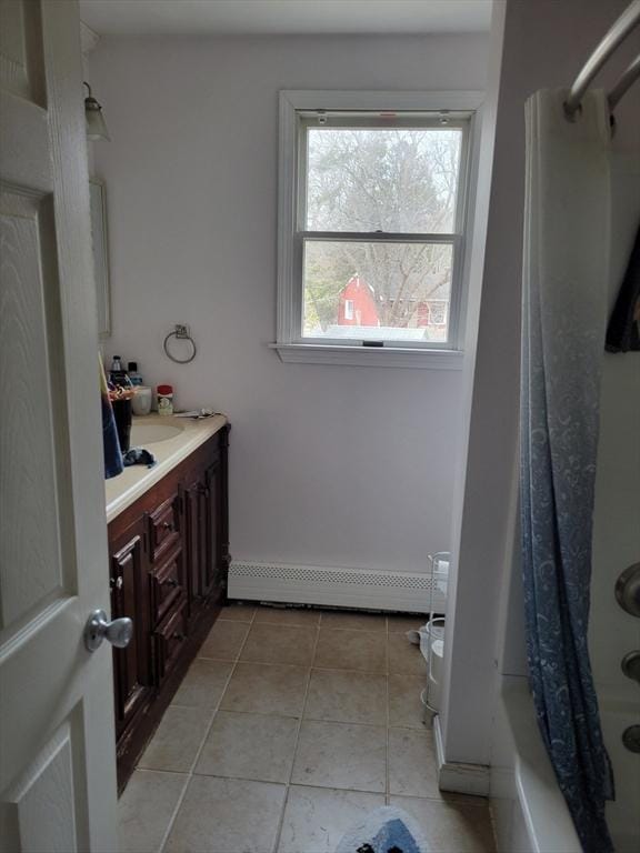 bathroom with a baseboard heating unit, shower / bath combo, tile patterned flooring, and vanity