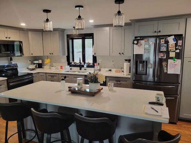 kitchen featuring stainless steel microwave, gray cabinetry, a sink, refrigerator with ice dispenser, and black / electric stove