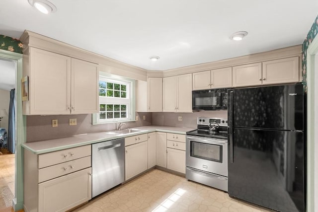 52 Harding Rd, Lexington, MA 02420 - kitchen with black appliances, cream cabinetry, a sink, and light countertops