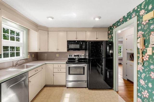 52 Harding Rd, Lexington, MA 02420 - kitchen with black appliances, light countertops, cream cabinets, radiator, and wallpapered walls