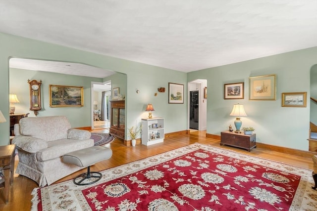 52 Harding Rd, Lexington, MA 02420 - living room featuring arched walkways, wood finished floors, and baseboards
