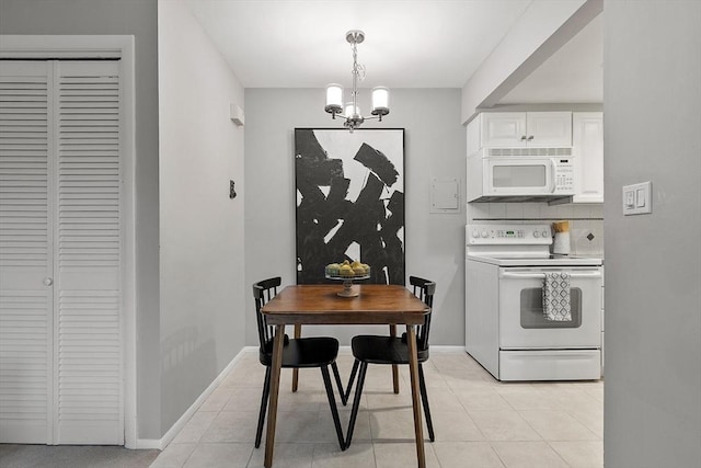 dining area with a chandelier, light tile patterned floors, and baseboards
