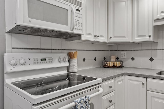 kitchen with white appliances, white cabinetry, and tasteful backsplash