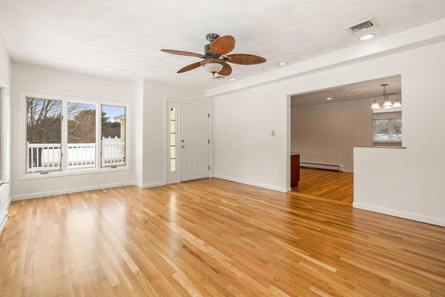 unfurnished room with ceiling fan with notable chandelier, wood-type flooring, and baseboard heating