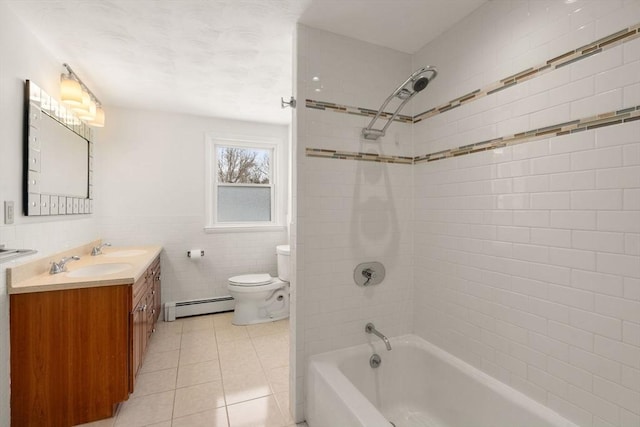 full bathroom with tiled shower / bath, tile walls, vanity, a baseboard heating unit, and tile patterned floors