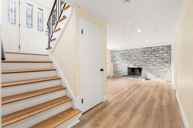 stairs with hardwood / wood-style floors and a fireplace