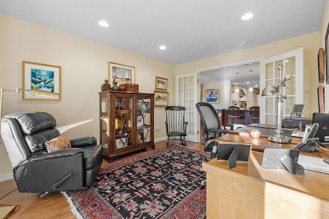 office with hardwood / wood-style floors and french doors