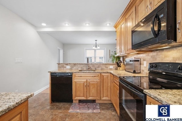 kitchen featuring light stone counters, a peninsula, a sink, black appliances, and tasteful backsplash