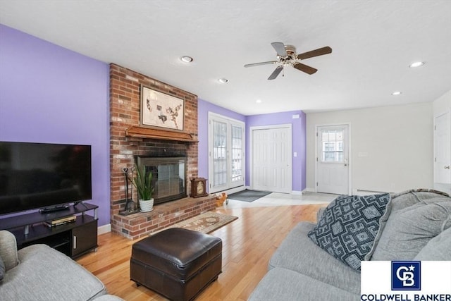 living room with a fireplace, recessed lighting, light wood-style flooring, ceiling fan, and baseboards