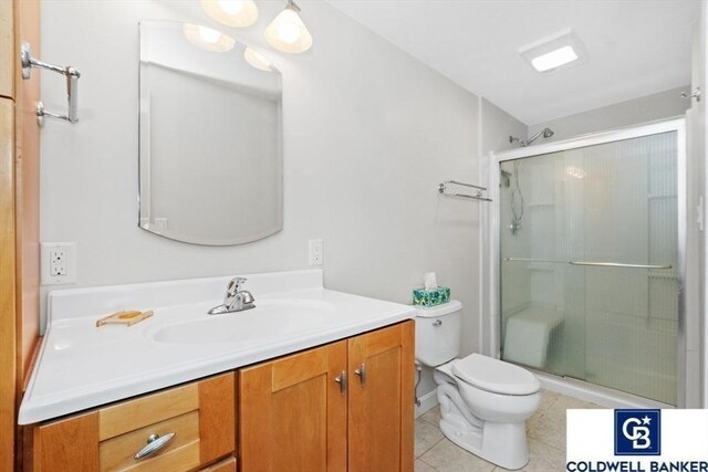 bathroom with toilet, a shower stall, tile patterned flooring, and vanity