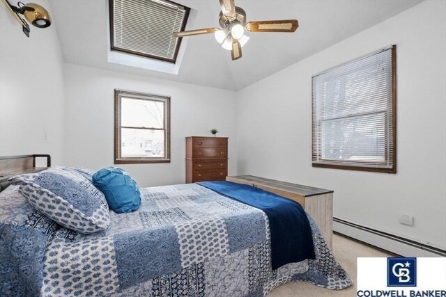 bedroom with carpet floors, ceiling fan, and baseboard heating