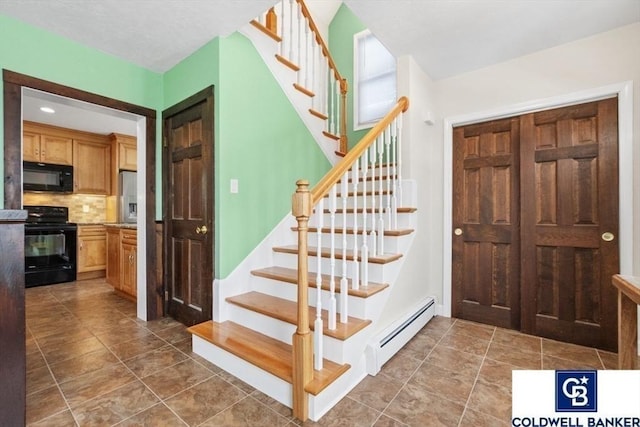 entryway featuring a baseboard radiator and stairs