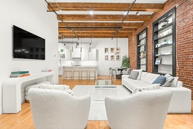 33 Sleeper St Unit 106, Boston, MA 02210 - living area featuring brick wall, light wood-style flooring, beam ceiling, and built in features