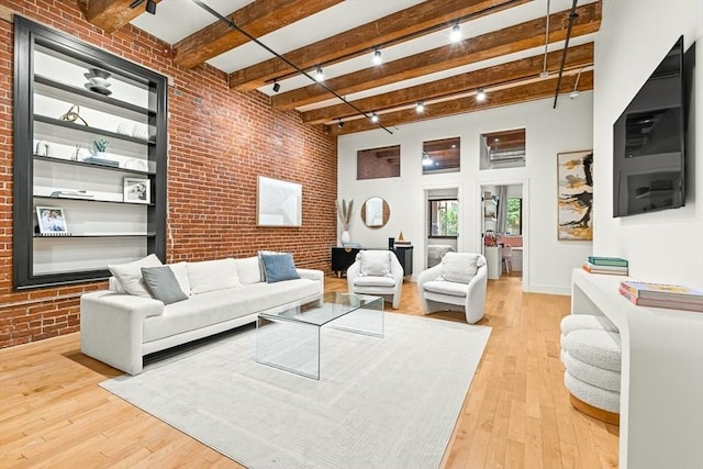 33 Sleeper St Unit 106, Boston, MA 02210 - living room with brick wall, beamed ceiling, hardwood / wood-style floors, and track lighting