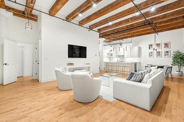 33 Sleeper St Unit 106, Boston, MA 02210 - living area with a high ceiling, light wood-style floors, and beamed ceiling