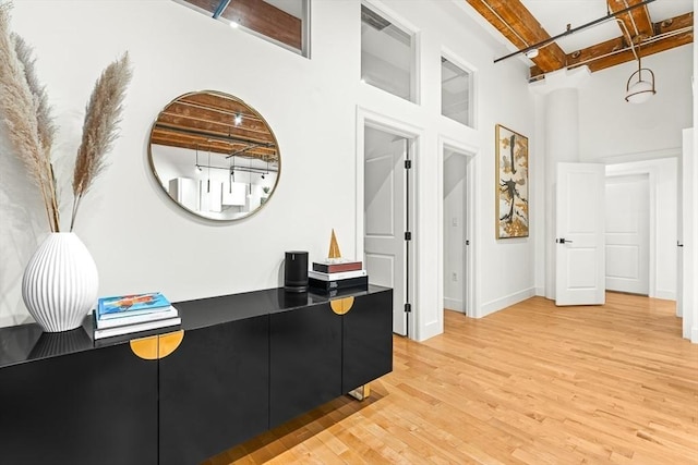33 Sleeper St Unit 106, Boston, MA 02210 - corridor featuring beam ceiling, light wood-style flooring, and a towering ceiling