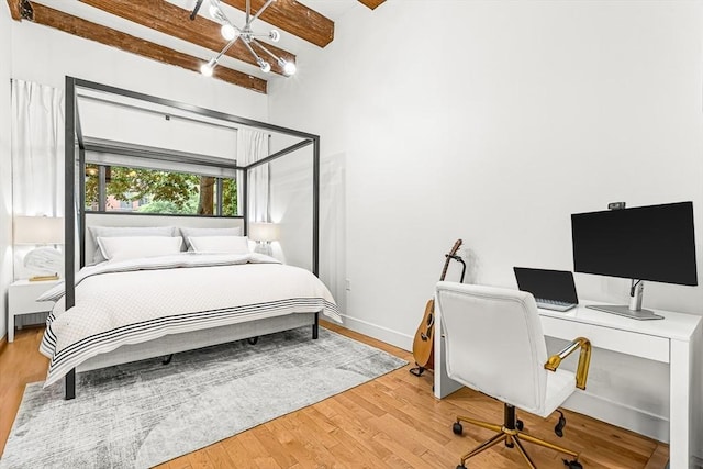 33 Sleeper St Unit 106, Boston, MA 02210 - bedroom with beamed ceiling, a desk, wood finished floors, and a chandelier