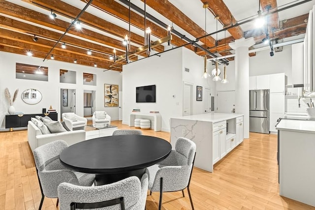 33 Sleeper St Unit 106, Boston, MA 02210 - dining room featuring a high ceiling, light wood-type flooring, and beamed ceiling