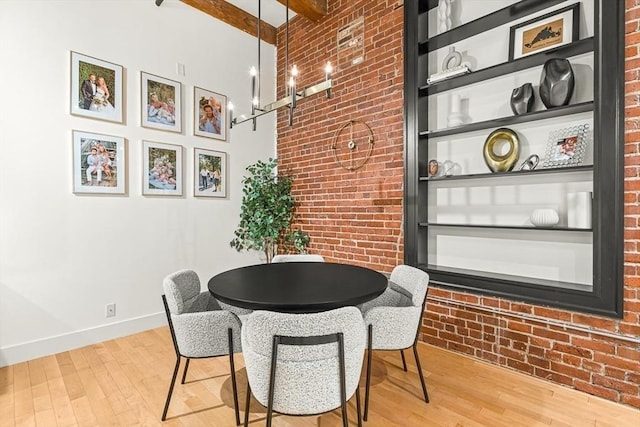 33 Sleeper St Unit 106, Boston, MA 02210 - dining space with brick wall, wood finished floors, and beamed ceiling
