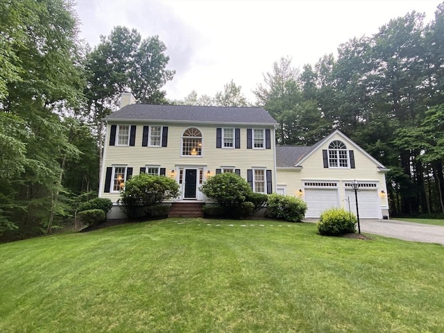 52 Cranberry Rd, Hanson, MA 02341 - colonial inspired home with a chimney, driveway, a front lawn, and an attached garage