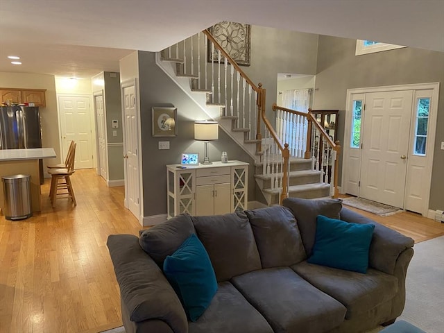 52 Cranberry Rd, Hanson, MA 02341 - living area with stairway, light wood-style flooring, and a towering ceiling