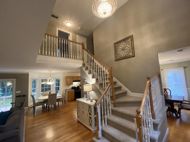 52 Cranberry Rd, Hanson, MA 02341 - staircase featuring a chandelier, wood finished floors, a high ceiling, and healthy amount of natural light