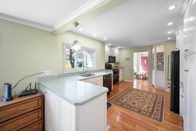 5 Northgate Rd, Chelmsford, MA 01824 - kitchen with black appliances, a peninsula, white cabinets, light countertops, and ornamental molding