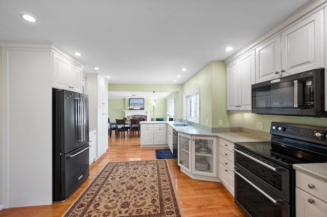 5 Northgate Rd, Chelmsford, MA 01824 - kitchen featuring freestanding refrigerator, range with two ovens, black microwave, a peninsula, and white cabinets