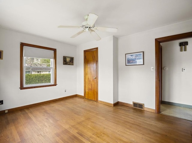 unfurnished room featuring light wood finished floors, baseboards, and a ceiling fan