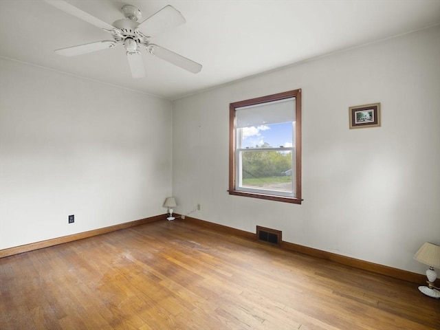 empty room featuring light wood finished floors, baseboards, and ceiling fan