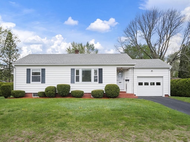 view of front of house featuring an attached garage, asphalt driveway, a chimney, and a front lawn