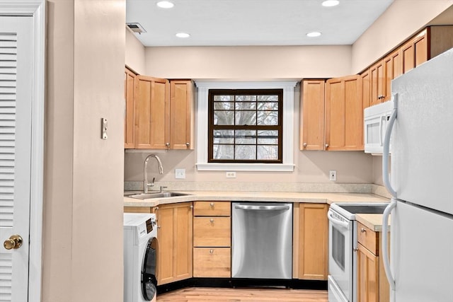 kitchen featuring washer / clothes dryer, white appliances, sink, and light wood-type flooring