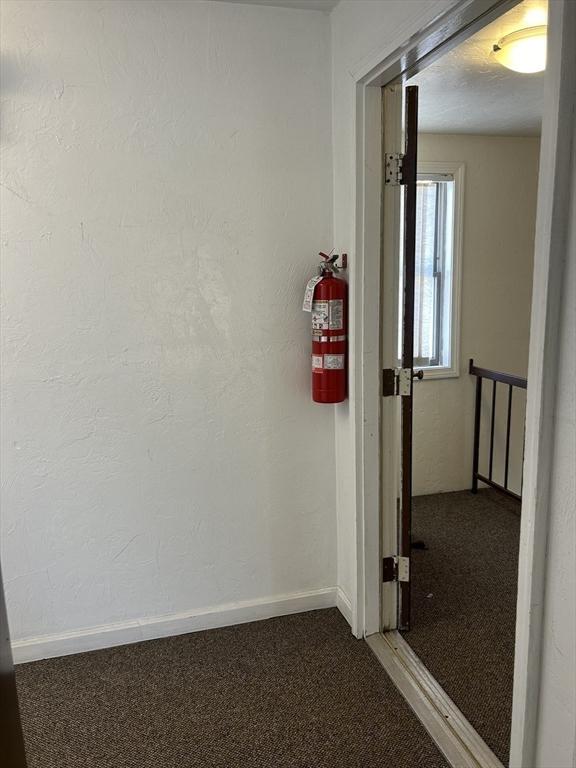 corridor featuring carpet flooring and baseboards