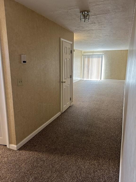 corridor with carpet floors and baseboards