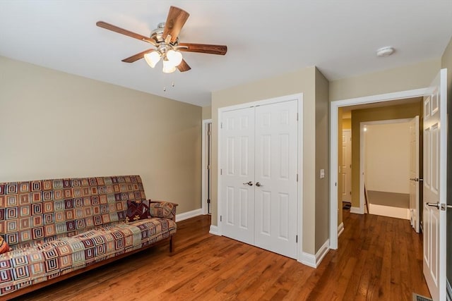 sitting room featuring a ceiling fan, visible vents, wood finished floors, and baseboards