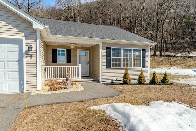 view of front of home featuring a ceiling fan, covered porch, an attached garage, and roof with shingles