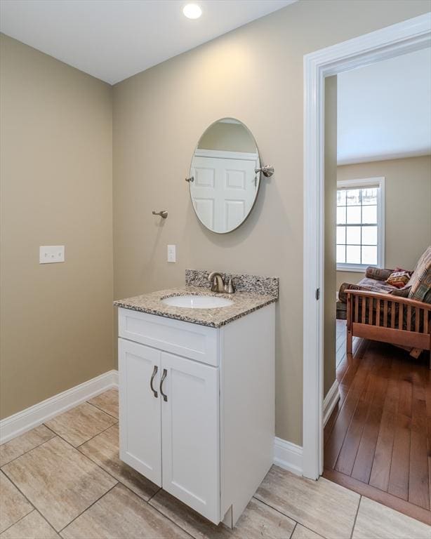 bathroom featuring vanity, wood finished floors, and baseboards