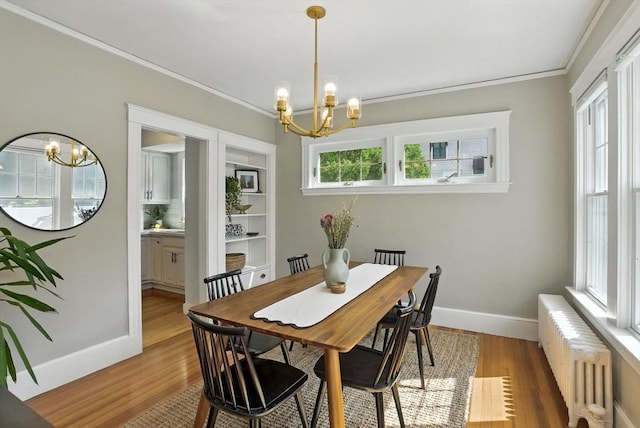 31 Dudley St, North Andover, MA 01845 - dining space featuring radiator, a chandelier, ornamental molding, and light wood-type flooring
