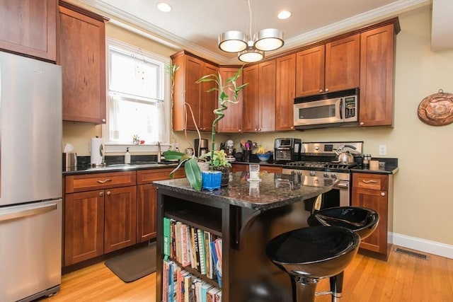 kitchen featuring appliances with stainless steel finishes, a sink, visible vents, and light wood-type flooring
