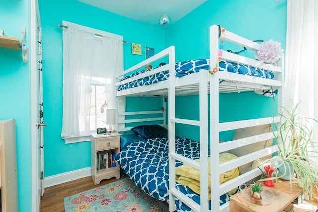 bedroom with baseboards and wood finished floors