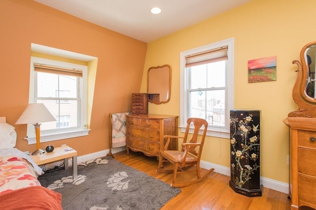 sitting room featuring baseboards, plenty of natural light, and wood finished floors
