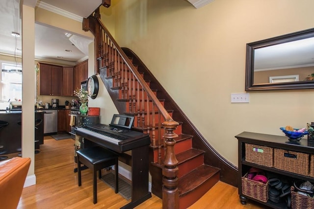 stairway featuring crown molding and wood finished floors