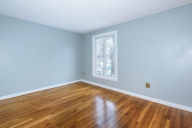 unfurnished room with baseboards and wood finished floors